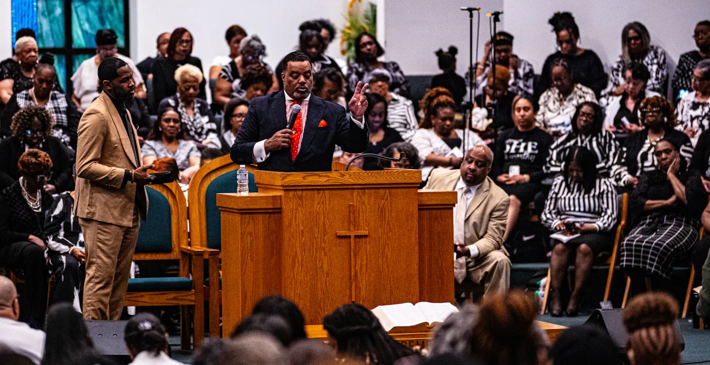 Gospel singer performing with microphone under stage lighting — placeholder