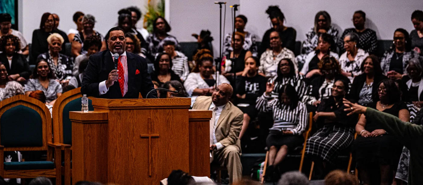Gospel singer performing with microphone under stage lighting — placeholder