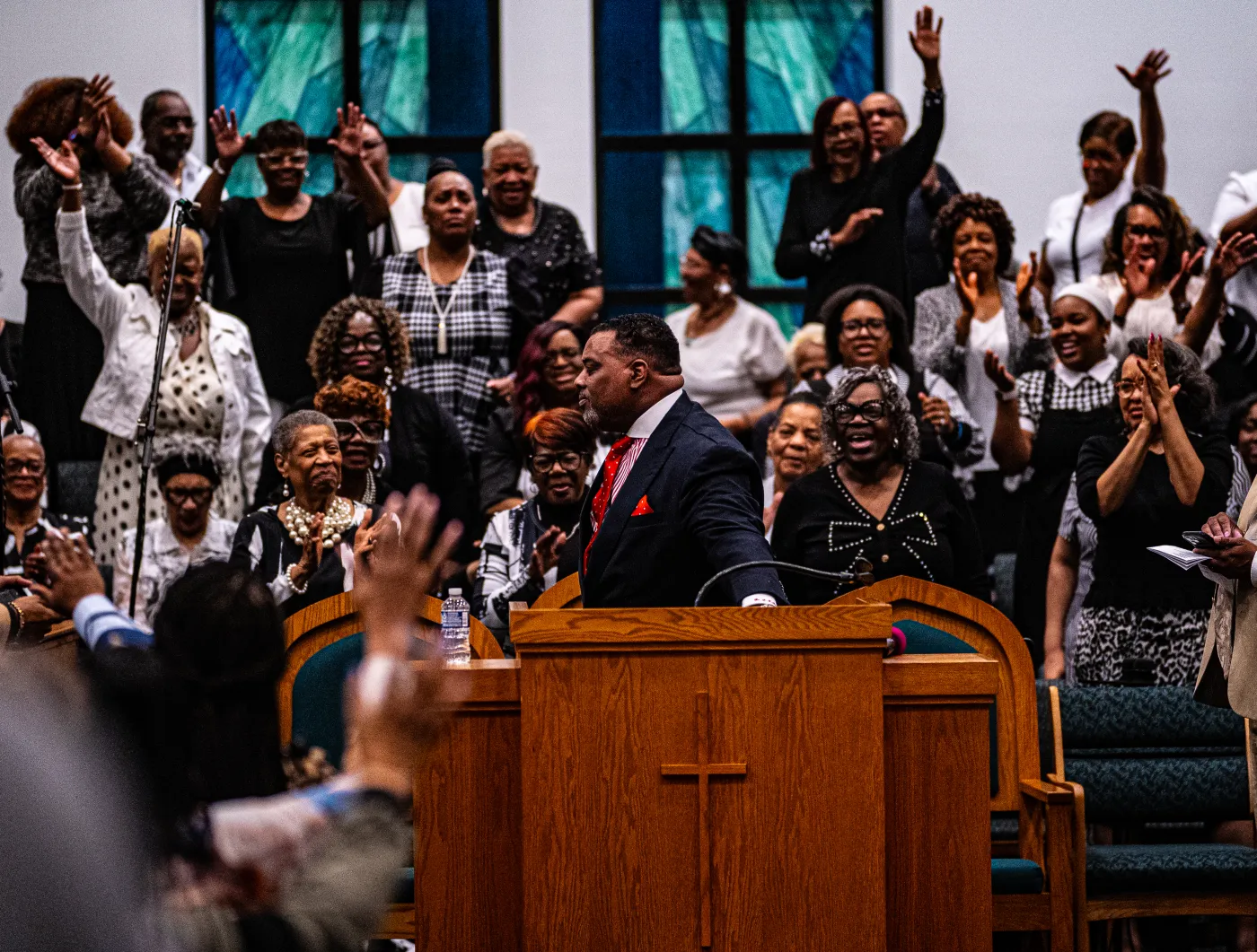 Gospel singer performing with microphone under stage lighting — placeholder